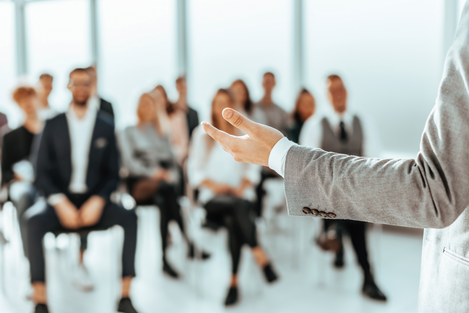 un-altoparlante-in-piedi-di-fronte-agli-ascoltatori-in-una-sala-conferenze (1)